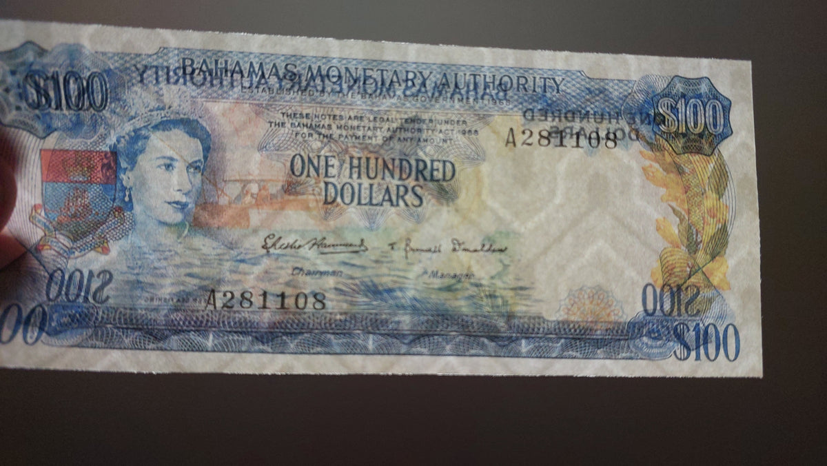 Detailed obverse view of the 1965 Bahamas 100 Pounds paper currency note.