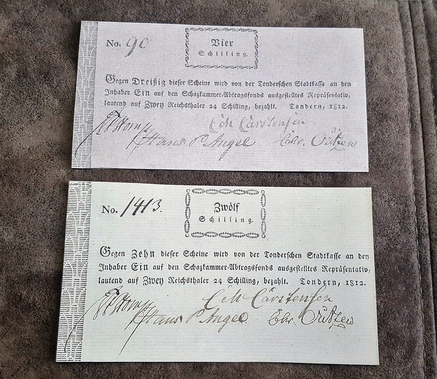 Historical German States early 19th-century paper money notes issued in Sundern, dated 1812, featuring denominations of 4 Schilling ("Vier Schilling") and 12 Schilling ("Zwölf Schilling") with handwritten serial numbers and official signatures.