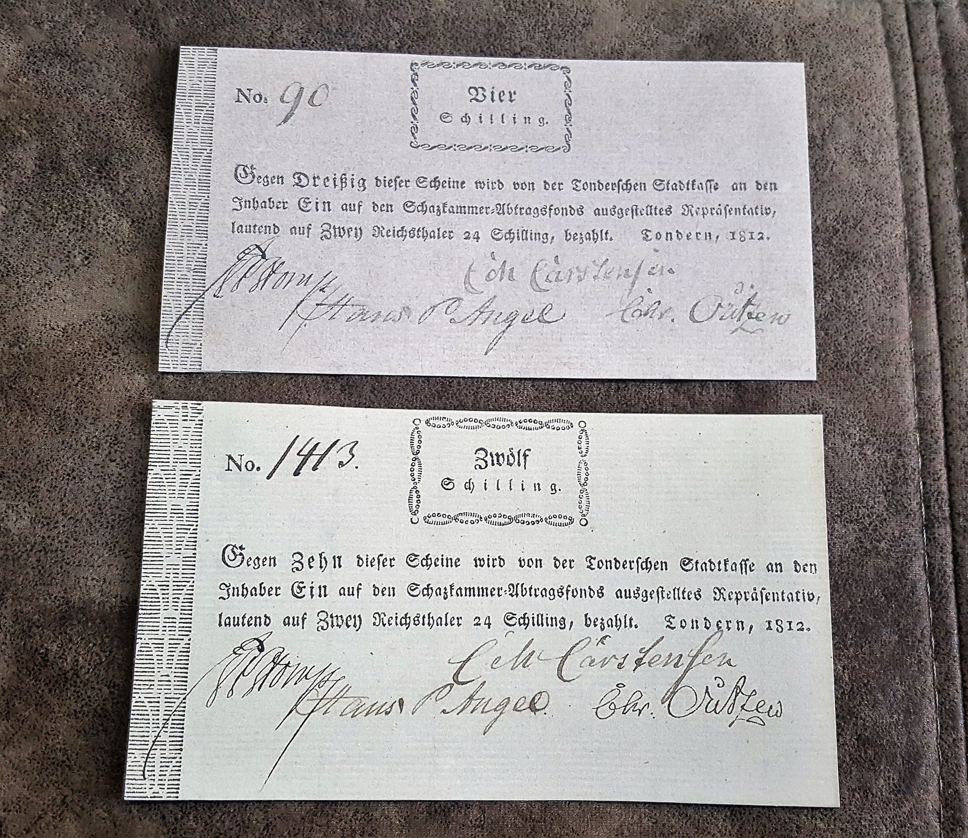 Historical German States early 19th-century paper money notes issued in Sundern, dated 1812, featuring denominations of 4 Schilling ("Vier Schilling") and 12 Schilling ("Zwölf Schilling") with handwritten serial numbers and official signatures.